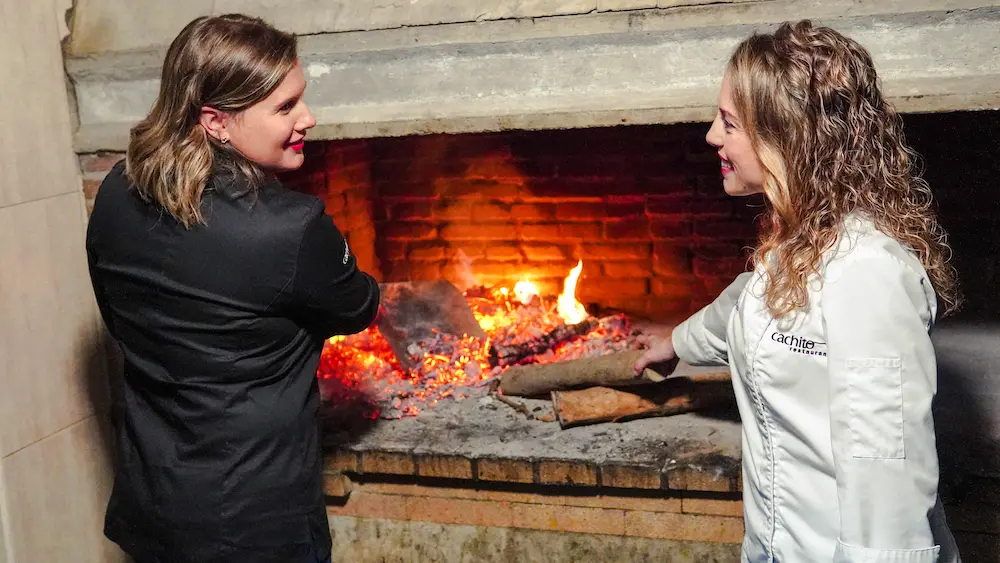 Noelia y Lidia Pascual junto al fuego de leña de la cocina