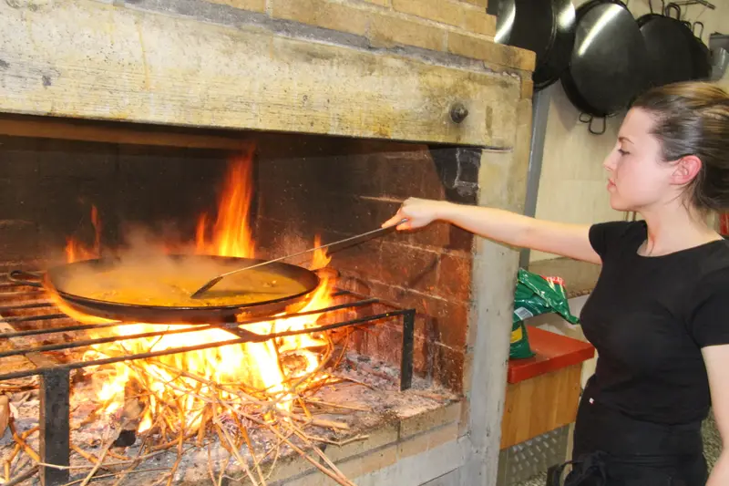Noelia Pascual cocinando un arroz sobre el fuego de sarmientos