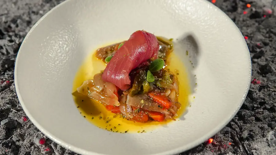 Atún rojo con verduras a la brasa en plato blanco sobre ceniza